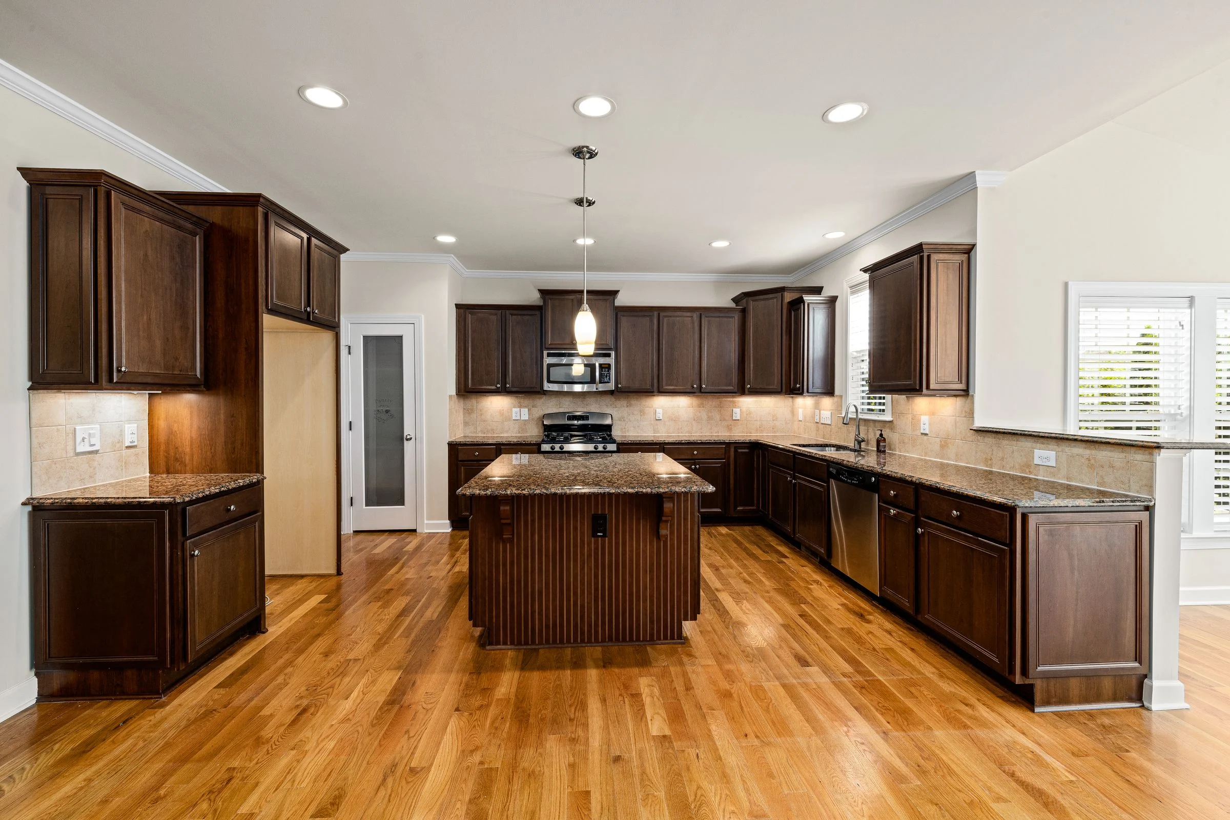 Kitchen with a dark wood island and hardwood flooring