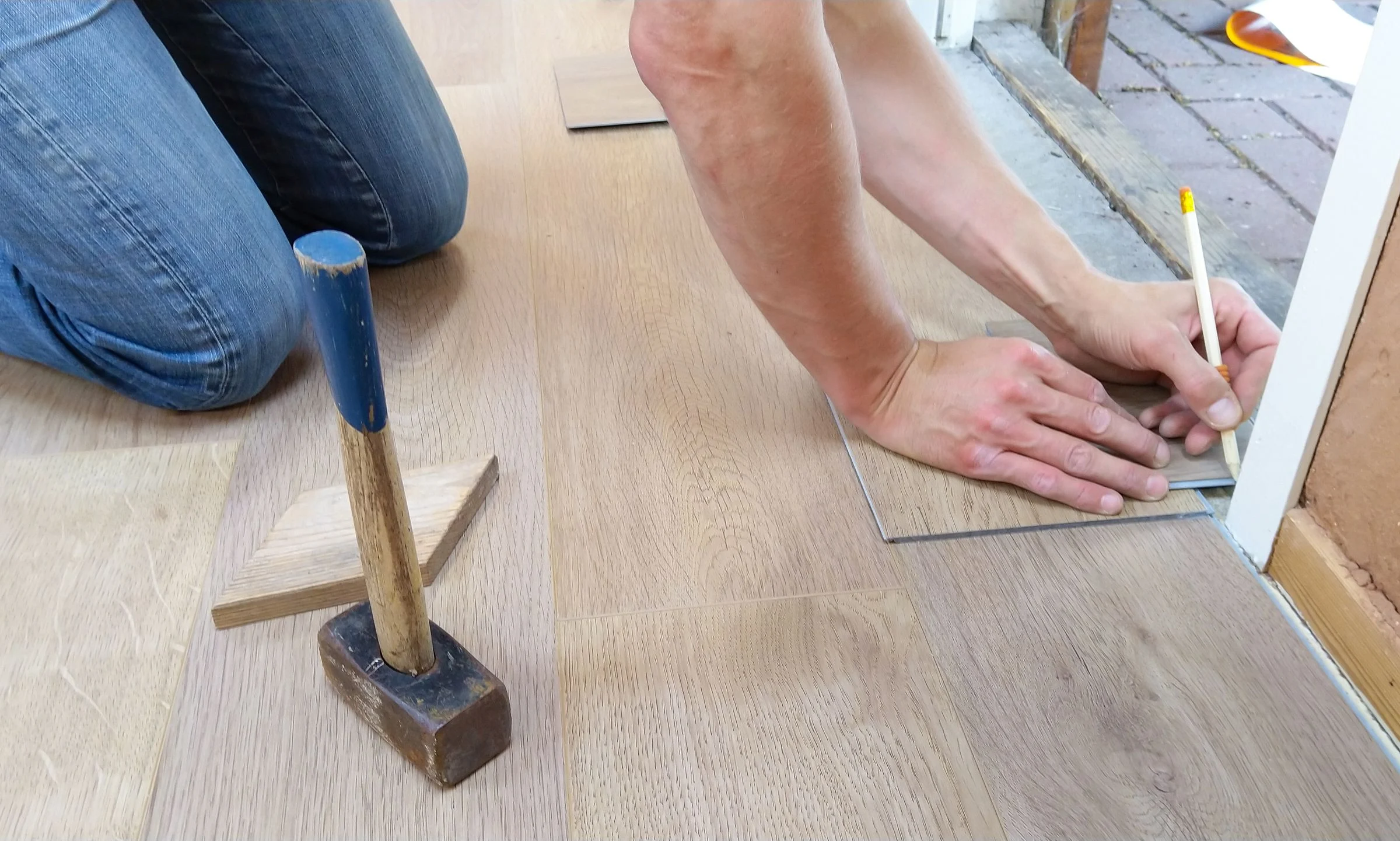 Installer measuring and fitting new plank flooring